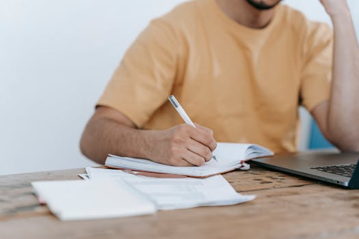 A student happily working at a desk with a planner open